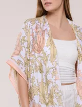 Kimono de gasa ligera con estampado floral en tonos beige y salmón, de silueta amplia, mangas cortas integradas y ruedo asimétrico con detalles de borlas en las puntas.