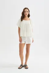 Blusa holgada de lyocell color blanco, con diseño plisado, escote cuadrado y mangas cortas abullonadas.