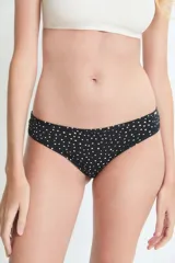 Bombacha tipo culotte less de color negro con estampado de lunares pequeños en color crema. Presenta un corte clásico con cobertura moderada.