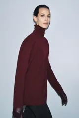 Jersey de corte oversize confeccionado en lana 100%, con cuello subido y manga larga.