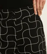 Short de vestir negro con estampado de líneas curvas blancas, de corte recto y cintura alta.