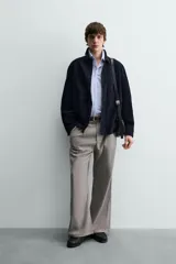 Sobrecamisa de hombre, color azul marino oscuro, confeccionada en piel con acabado ante. Presenta cuello solapa, manga larga con puños abotonados, un bolsillo de parche en el pecho y cierre frontal de botones.