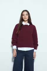 Sweater de tejido texturizado con líneas horizontales en relieve, de silueta levemente holgada y hombros caídos.