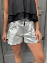 Short plateado de eco cuero metalizado elastizado, de tiro alto y corte acampanado.