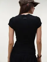 Remera blanca de manga corta y cuello redondo, confeccionada en tejido rib texturizado con corte entallado al cuerpo.