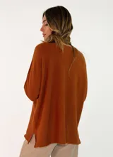 Sweater de punto color verde oliva, con cuello redondo, mangas largas y diseño holgado con costuras visibles en los laterales.