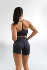 Top deportivo negro con efecto lavado, breteles finos y espalda deportiva.