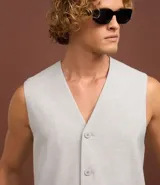 Chaleco gris de poliéster y viscosa, con cuello en V, abotonado delantero y bolsillos decorativos.