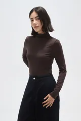 Polera de poliamida ajustada al cuerpo, con cuello alto y mangas largas.