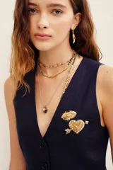 Pin metálico con diseño de labios dorados.