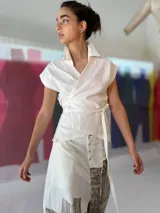 Falda larga blanca de lino y algodón con estampa exclusiva en cobre laminado. Corte asimétrico, tajo central y un bolsillo lateral. Cierre frontal con broches a presión.