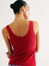 Musculosa de tela acanalada con cuello redondo y pliegues laterales que aportan textura y un ajuste entallado al cuerpo.