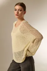 Sweater de tejido de punto calado con lurex, cuello redondo a la base y mangas largas con diseño holgado.