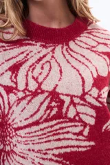 Buzo tejido de punto con diseño floral estampado en contraste, cuello redondo y terminaciones en rib. Presenta un calce holgado y mangas largas.
