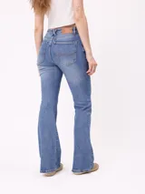 Jean de corte acampanado (flare fit) en color azul lavado, con tiro medio, cierre frontal con botón y bolsillos laterales y traseros.