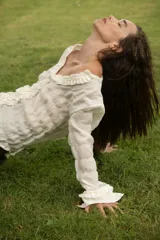 Camisa negra de manga larga con detalle de volados en el frente y puños.