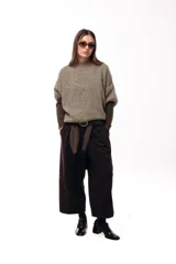 Sweater de tejido de punto grueso con silueta amplia y mangas 3/4. Presenta un diseño de calce relajado con cuello redondo y textura voluminosa.