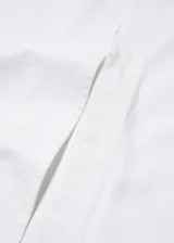 Falda midi de jean blanca, de corte recto, con cierre de cremallera y botón, trabillas, cinco bolsillos y abertura frontal.