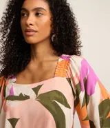 Blusa de mangas cortas con escote cuadrado y estampado floral en tonos rosa, naranja, verde y blanco.