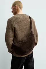 Bolso de hombro con diseño de media luna, confeccionado en piel con acabado de serraje. Cuenta con un asa integrada y cierre principal mediante cremallera.