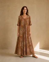 Vestido largo terracota con estampado floral difuminado, escote en V, mangas cortas holgadas y diseño amplio y fluido.