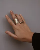 Anillo abierto de diseño rústico y orgánico, con textura irregular que evoca la naturaleza. Realizado artesanalmente en metal.
