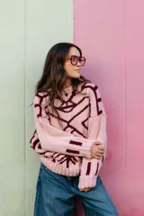 Sweater de punto oversize con diseño jacquard geométrico en tonos gris y crema. Presenta cuello redondo a la base, mangas largas y terminaciones en punto elástico acanalado.