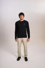 Sweater de punto con textura acanalada, color negro, de cuello redondo y manga larga. Presenta un pequeño logo bordado en el pecho.