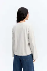 Remera de manga larga con corte oversize, cuello redondo y hombros caídos, confeccionada en algodón.