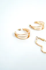 Set de tres pares de aros plateados de diseño variado: un par de argollas dobles, un par de aros con forma de corazón y un par de argollas pequeñas con textura rayada.