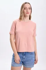 Remera de manga corta color rosa con cuello redondo y puños en las mangas.