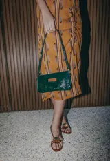 Mini cartera de cuero color crudo con correa larga extraíble y bolsillo interno con cierre.