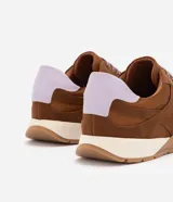 Championes estilo retro runner Satinato de color marrón, con capellada en tejido y recortes de gamuza sintética. Cuentan con cordones bicolores, detalle en lila en el talón y suela texturizada.