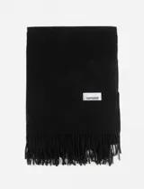 Pashmina de textura suave en color negro, con diseño liso y flecos en los extremos. Incluye una etiqueta blanca con el logo de la marca en la parte frontal.
