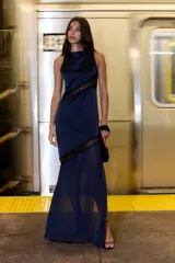 Vestido largo azul marino sin mangas, con cuello alto drapeado y detalles diagonales de encaje negro semitransparente.