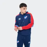 Canguro deportivo Umbro del Club Nacional de Football, color azul con capucha y cordones de ajuste, mangas rojas con detalles en celeste y blanco, bolsillos tipo canguro y el escudo del club junto con el logo de Umbro bordados en el frente.