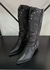 Botas texanas negras de caña alta con bordado de hojas en color blanco y tachas plateadas.