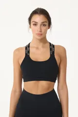 Top deportivo negro con espalda cruzada, elástico inferior y tiras regulables con logo Basset.