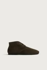 Bota de cordones tipo derby de la colección especial Aaron Levine x Zara, confeccionada en piel con acabado en serraje de color marrón. Cuenta con horma redonda, forro y plantilla interior de piel, y suela de goma Vibram.