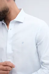 Camisa de manga larga fit semi slim color celeste, con cierre frontal de botones y cuello camisero clásico.