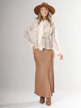 Camisa de encaje color crema, con corte clásico, volado frontal y botones al frente.