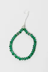 Correa colgante para celular de cuentas facetadas color verde esmeralda, con apliques plateados con strass y cordón superior blanco.