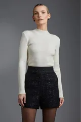 Short negro de tiro alto con textura tweed y detalles brillantes.