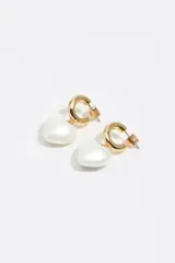 Caravanas doradas con argolla tipo criolla y dije colgante en forma de corazón color blanco perlado.