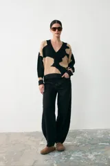 Sweater de punto con diseño animal print en bloques de color negro y beige, con cuello en V y terminaciones acanaladas en puños y ruedo.