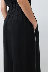 Mono negro de lino con corte recto, cuello camisero, sin mangas y vivo blanco en contraste en cuello, sisas y laterales.