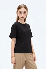 Remera blanca de manga corta, cuello redondo a la base y diseño holgado, confeccionada en algodón.
