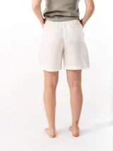 Short de lino con cintura elástica y cordón ajustable. Cuenta con dos bolsillos laterales y un bolsillo trasero, ofreciendo un ajuste cómodo y versátil.