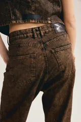 Jean baggy de denim color marrón con efecto acid wash, corte amplio y relajado en toda la pierna, tiro medio y bolsillos clásicos.