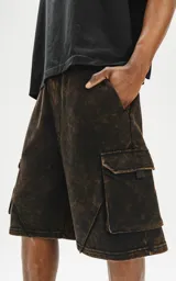 Bermuda cargo de algodón rústico, color marrón oscuro con efecto desgastado (acid wash/oxidado). Presenta un calce oversize, cintura elástica y grandes bolsillos laterales con tapa.